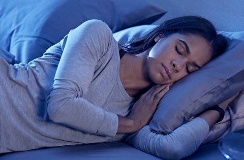 Misty Copeland, sleeping peacefully in a bed, wearing TB12 Sleep Recovery sleepwear.