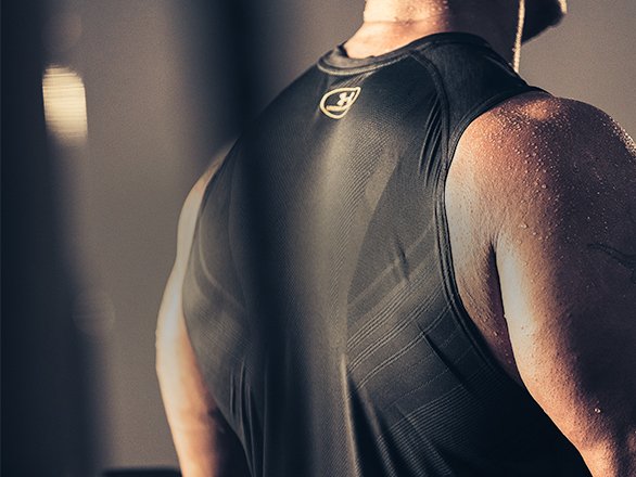 Close up of the back of a guy working out wearing a UA SuperVent training tank with mesh details