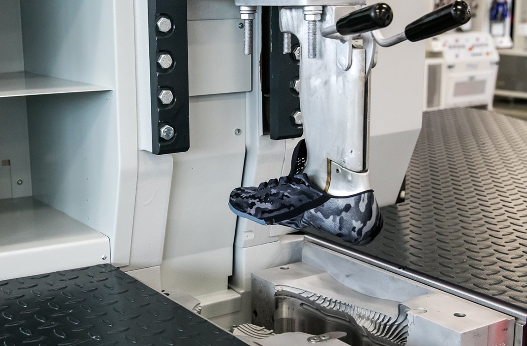 A footwear machine with a black camo UA shoe mold on it being tested in the UA Lighthouse
