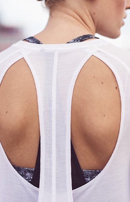 Back of grey UA French Terry Open Back Hoodie being worn with blue UA Armour Eclipse Sports Bra