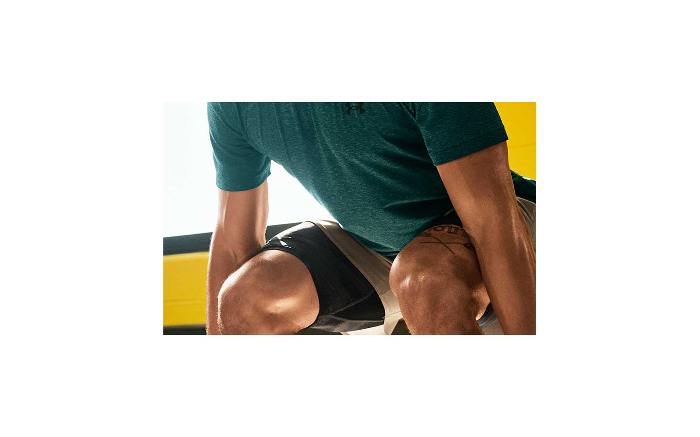 A man wearing a green t-shirt exercising indoors
