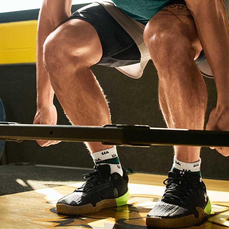 A man with a muscular build performing a deadlift exercise with lifting barbell 