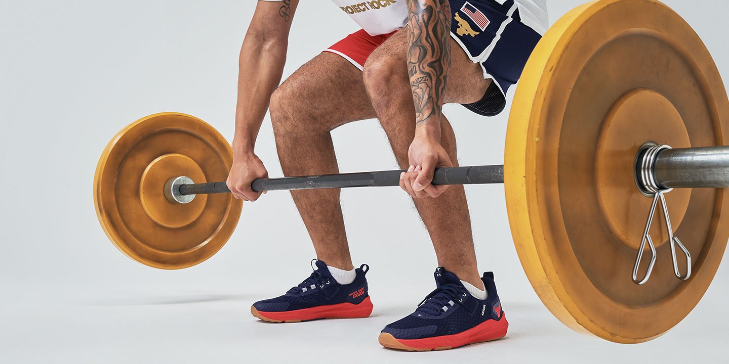 A man performing a deadlift exercise with yellow lifting barbell 